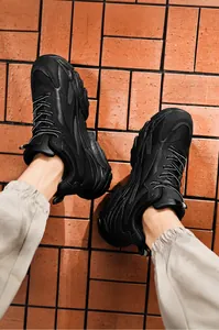 Detailed view of black chunky dad sneakers on model with thick shock-absorbing sole