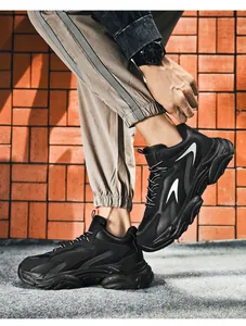 Close-up of black chunky sneakers featuring gray mesh panels and durable thick soles
