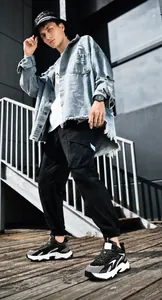 Outdoor street style view of men's chunky sneakers with jogger pants and denim jacket