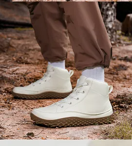 Vista lateral de botas de senderismo crema con suelas de goma antideslizantes