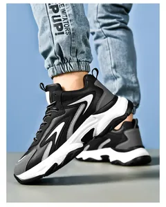 Side view of men's chunky dad sneakers with black, white, and grey color blocking design
