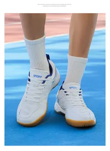 Vue de dessus de chaussures de badminton respirantes avec accents bleus sur piste