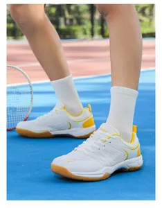 Détail de chaussures de badminton professionnelles blanc et jaune sur terrain de sport