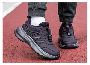 Close-up of dark purple walking shoes with quick lace system on a red running track