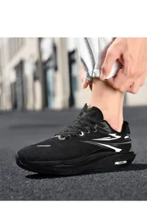 Detail of black breathable mesh running shoes with white lightning stripes on the street