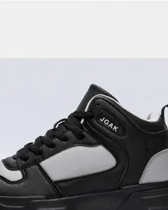 Macro detail of the grey and black leather panels and JGAK logo on the casual sneakers