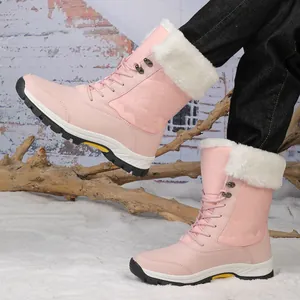 Detalle de botas de nieve rosas con ribete de piel sintética blanca y costuras de diamantes
