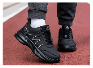 Detail of black walking shoes with thick cushioned sole and quick-lace toggles on track