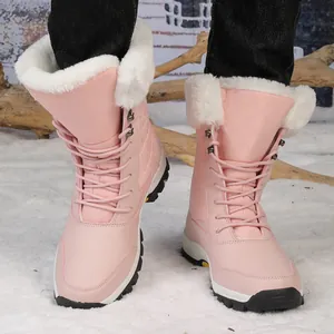 Detalle de botas de nieve rosas con cuello de piel sintética blanca y textura acolchada