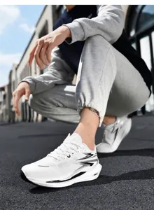 Detail of white breathable mesh running shoes with cushioning sole on street pavement