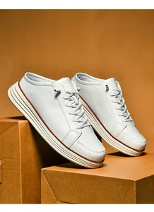 Detailed macro view of white leather mule sneakers with brown stitching on thick platform soles