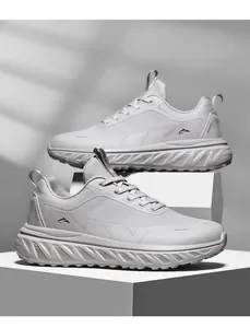 Close-up of white breathable mesh sneakers with chunky anti-slip sole and running logo