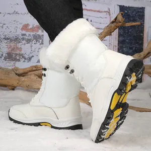 Detalle de bota de nieve blanca con cuello de pelo sintético y diseño acolchado en nieve