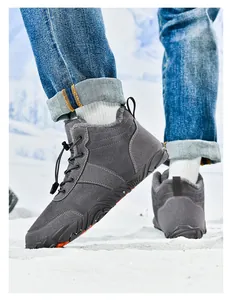 Close-up of dark grey thermal winter boots with plush lining on snowy outdoor ground