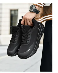 Detail of man holding black wide-fit running shoes with breathable mesh and thick soles