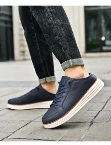 On-foot view of men's navy blue slip-on shoes with thick white soles on stone ground