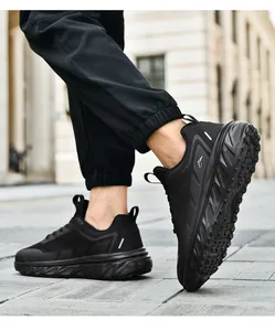 Detail of all-black breathable mesh sneakers with thick cushioned soles for outdoor walking