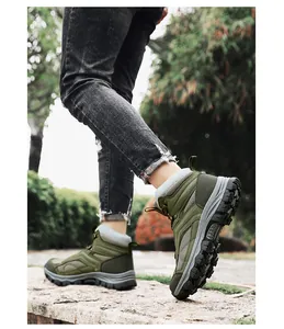 Close-up of olive green hiking boots on a rocky path with durable metal eyelets