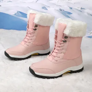 Detalle de botas de nieve rosas con forro de felpa y suelas de goma antideslizantes en la nieve