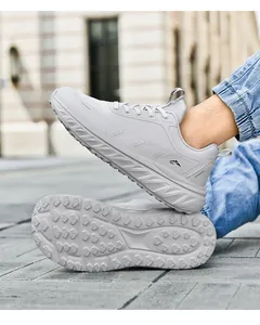 Outdoor shot of light gray running shoe featuring thick cushioned sole and grip patterns