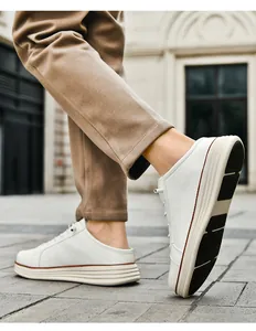 Close-up of men's white leather slip-on mule sneakers with thick textured rubber soles