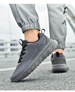 Vista dal basso di scarpe da corsa grigio scuro da uomo con mesh e suola spessa all'aperto