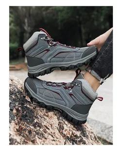 Detail view of grey outdoor hiking boots with thick rubber soles and fabric texture