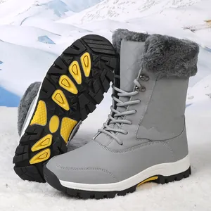 Vista detallada de botas de nieve grises con textura acolchada y ribete de piel sintética