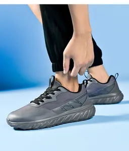 Vista laterale di scarpe da corsa grigie da uomo a pianta larga con suole spesse