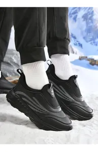 Men's thermal winter walking shoes with non-slip soles on a snowy mountain background
