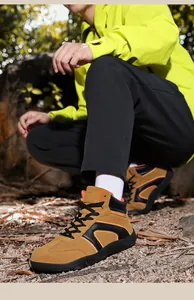 Detail of high-top hiking boots featuring khaki suede upper and thick rubber soles