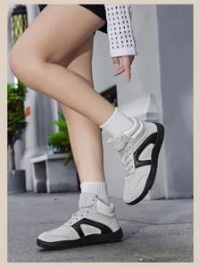 On-foot look of high-top grey and black suede sneakers with stylish V-shaped accents