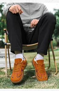 Close-up of yellow suede casual sneakers with contrast side stripes and perforated toe box