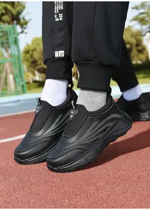 Close-up of black slip-on casual sneakers with thick cushioning sole on outdoor track