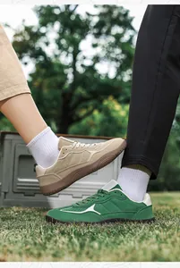 Outdoor close-up of beige and green suede sneakers with durable rubber soles