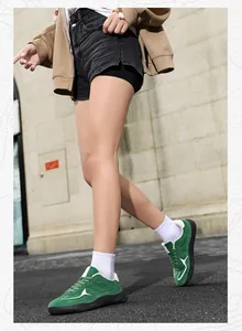 Close-up of green suede sneakers with white wave pattern and thick black rubber soles