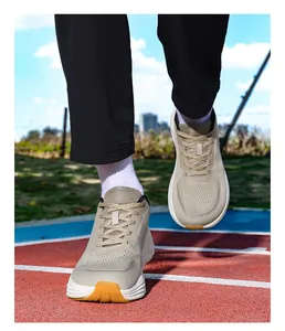 Dettaglio scarpe da corsa beige a pianta larga con mesh traspirante su pista atletica