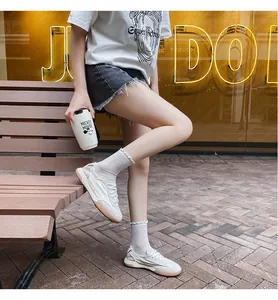 Detail of white leather low-top sneakers with gum soles and ruffled crew socks