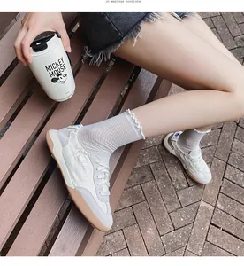Close-up of ballet-style leather sneakers with Angel embroidery and lace socks