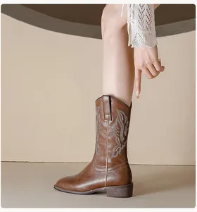 Detail shot of vintage brown cowboy boots featuring intricate light-colored embroidery