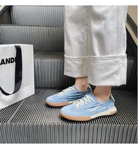 Close-up of light blue leather retro sneakers with Angel embroidery on escalator