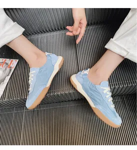 Detail of light blue leather ballet trainer featuring caramel rubber sole on escalator