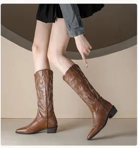 Close-up of brown western cowboy boots with white embroidery detail and chunky heel