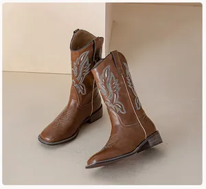 Detail shot of vintage brown cowboy boots with white western embroidery and low block heels