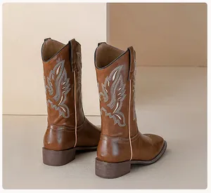 Detailed embroidery on vintage brown western cowboy boots with chunky mid-heels