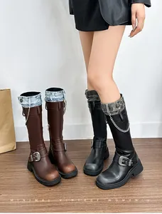 Detail of vintage platform boots with metal chains and distressed denim patchwork trim