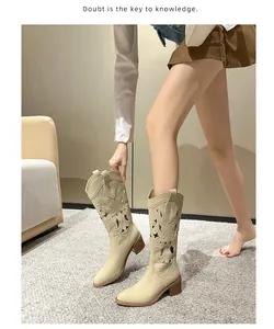 Detail of beige western cowboy boots featuring hollow embroidery and a chunky wooden heel