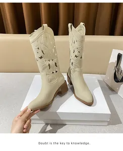 Detailed view of beige Western cowboy boots featuring hollow embroidery and stacked heels