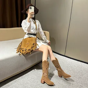 Brown suede cowboy boots with bohemian embroidery and matching tassel shoulder bag