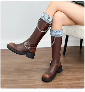 Close-up of brown platform riding boots with vintage finish and silver metal chains